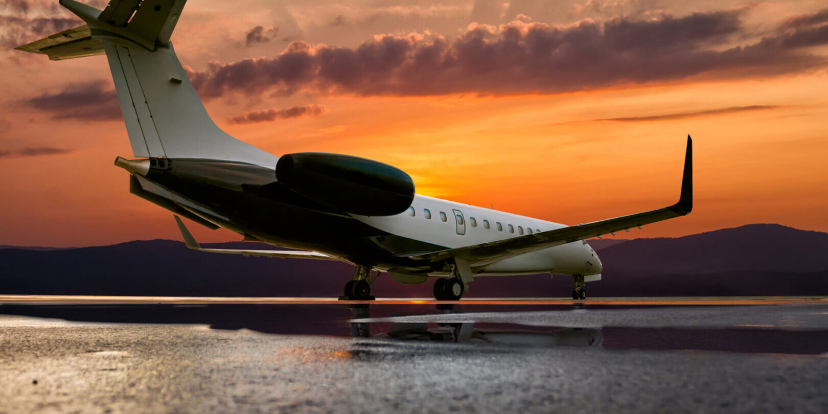 Corporate jet plane on the background of a picturesque sunset on the airport apron