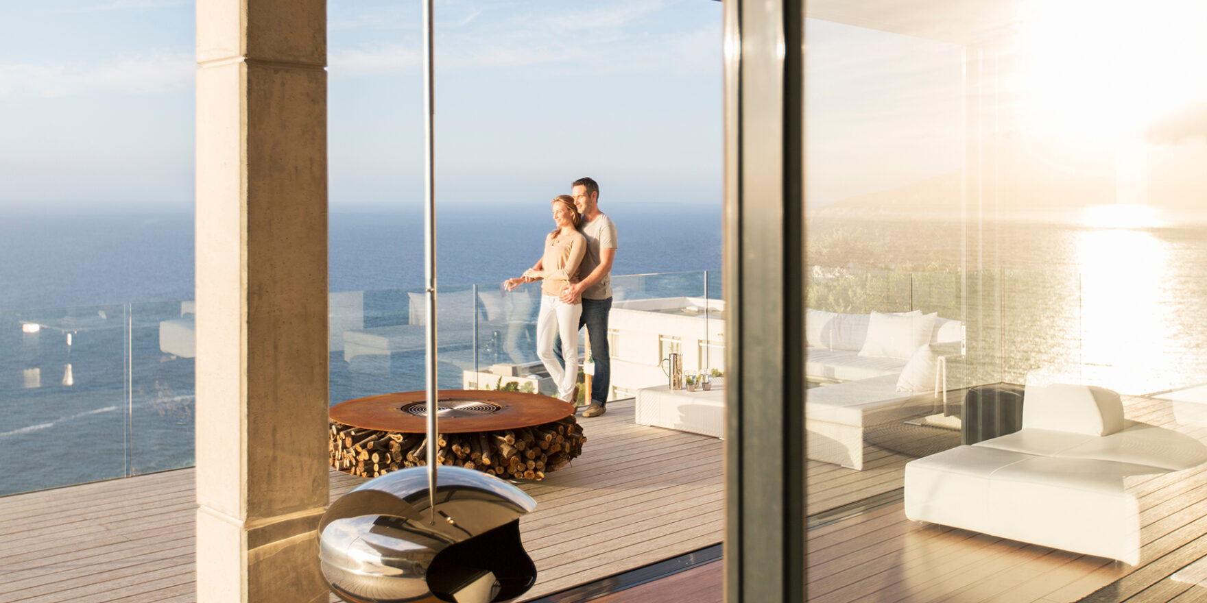 Couple on modern balcony overlooking ocean